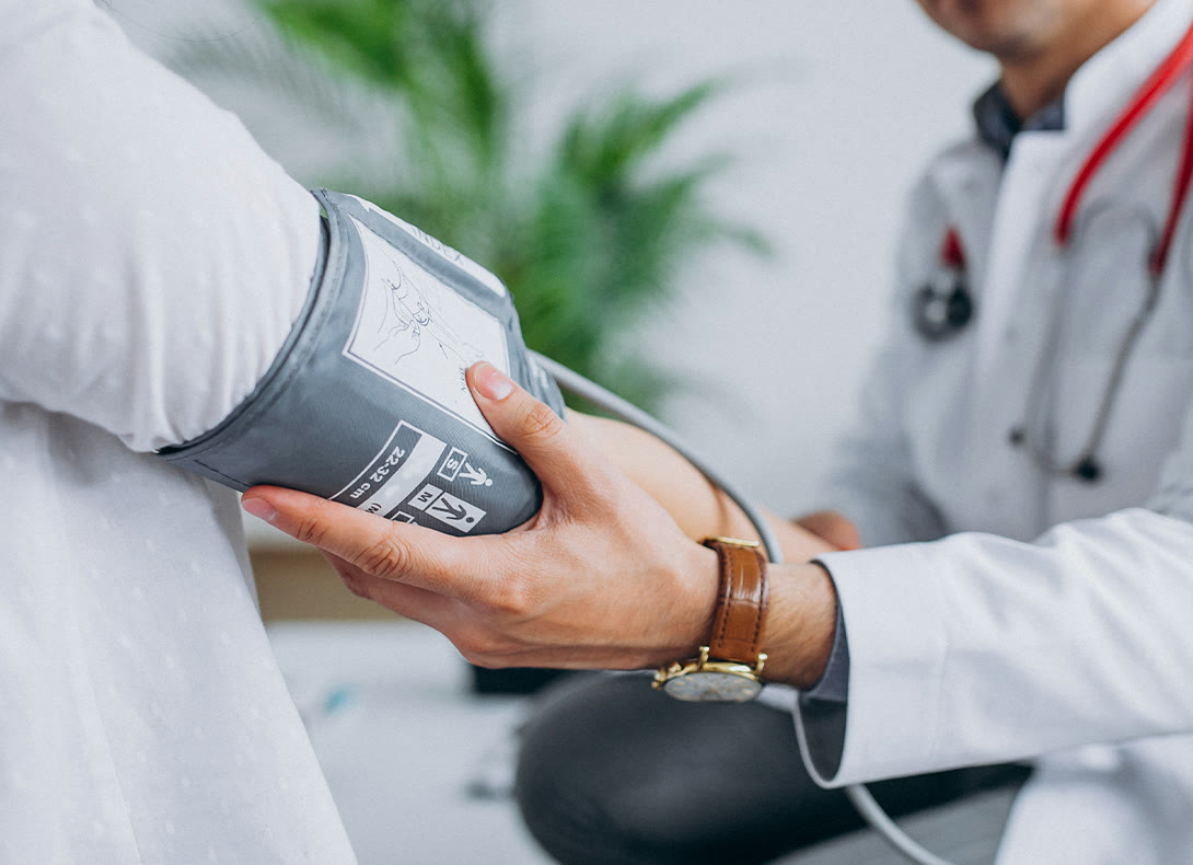 A doctor taking a patient’s blood pressure during a visit
